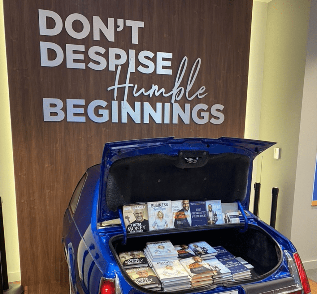 Image of car trunk open full of books with quote: Don't despise humble beginnings